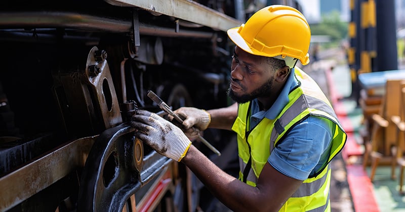 Male worker using a wrench on a piece of machinery